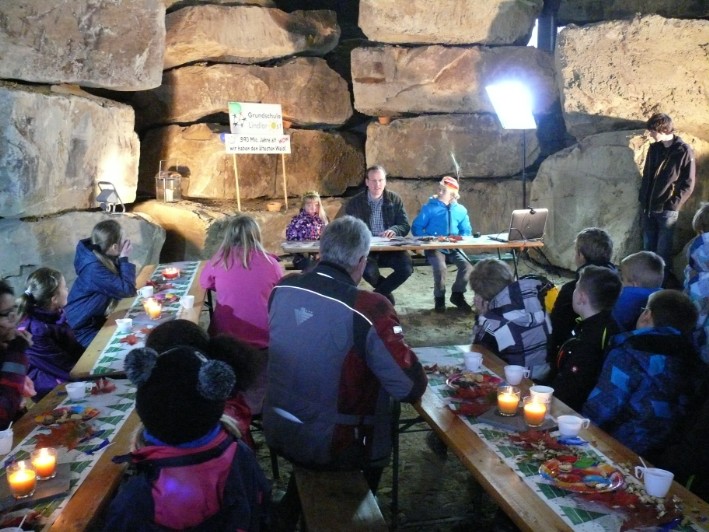 Bundesweiter Vorlesetag. Ungewöhnlicher Vorleseort im Steinbruch Schiffarth vor der Kulisse von Grauwacke-Rohblöcken.